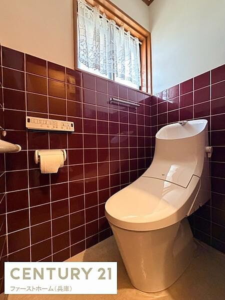窓からの自然光が入るトイレは明るく清潔感のある空間です。タイルの壁が落ち着いた印象を与えています。ペーパーやリモコンも手に取りやすい配置です。洗練されたデザインで日々の利用がしやすいです。