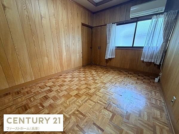 木目調の壁と床が落ち着いた雰囲気を演出しています。大きな窓から採光がしっかりと入ります。エアコン設置済みで快適な温度管理が可能です。カーテン付きでプライバシーも確保されています。