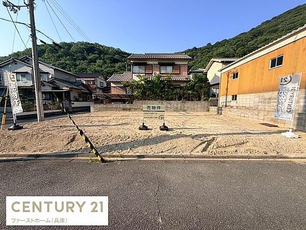 現地土地写真では整地された広々とした敷地がご覧いただけます。周囲には住宅や緑豊かな自然が広がり落ち着いた雰囲気のエリアです。敷地内には販売中の表示があり現況でのご確認が可能です。