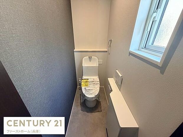 清潔感のあるトイレ空間です。窓付きで換気がしやすく快適な使用が可能です。シンプルな内装が特徴となっています。収納スペースも設けられており利便性にも配慮されています。