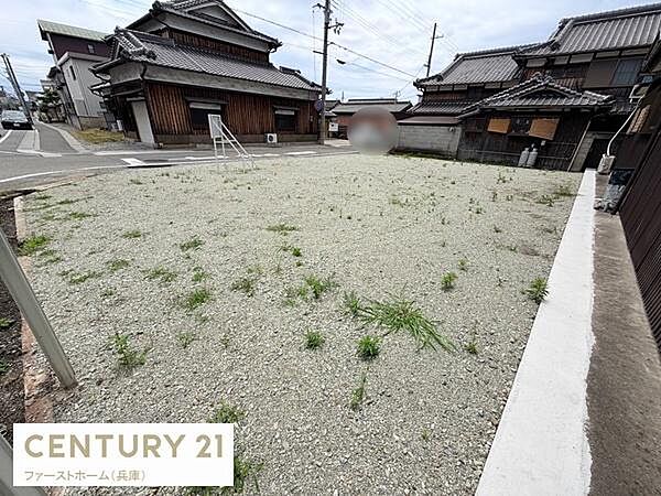 道路に面した現地土地写真です。整った形状の土地で周囲には落ち着いた住宅が並んでいます。通行のしやすい立地で角地が印象的です。周辺環境も整備されており見通しの良い区画です。