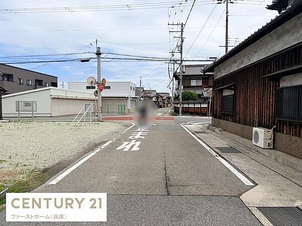 前面道路は舗装されており通行しやすい環境です。周囲には落ち着いた住宅が並んでいます。視界が開けていて見通しの良い立地が印象的です。電柱や標識も整備され地域のインフラが整っています。