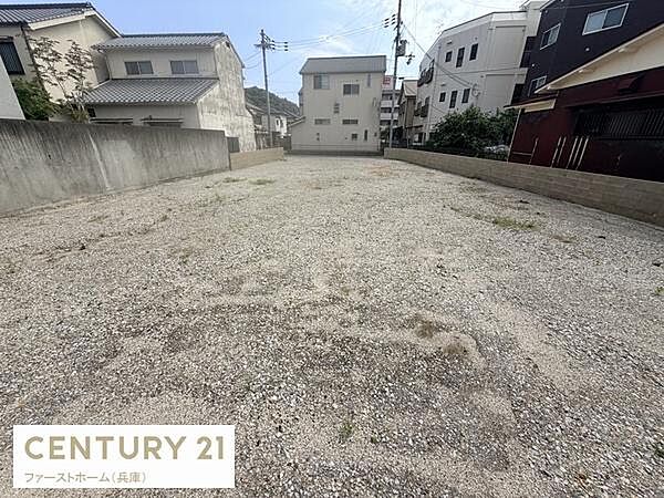 周囲に住宅が立ち並び落ち着いた雰囲気の現地土地写真です。両側が塀で囲まれており視界が広がる開放的な区画となっています。整地されており利用しやすい印象です。アクセスのしやすさも感じられます。