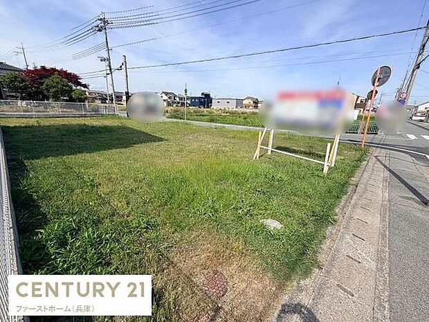 広々とした現地土地写真です。開放感のある角地で道路に面してアクセスも良好です。周辺には住宅や電柱が整然と並んでおり住宅用地としても利用しやすい環境です。陽当たりもしっかり確保されています。