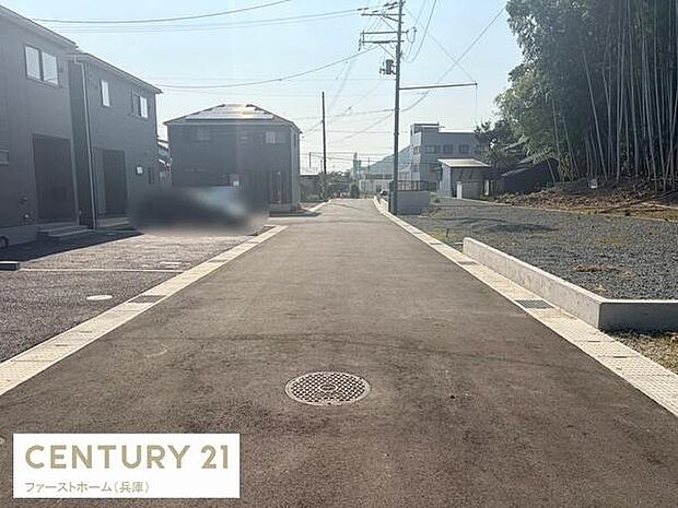 前面道路が広く車の出入りがしやすい環境です。舗装された道路が敷地の印象を引き立てます。周辺の住宅とも調和した雰囲気が感じられます。電柱や配線も整えられており落ち着いた景観です。