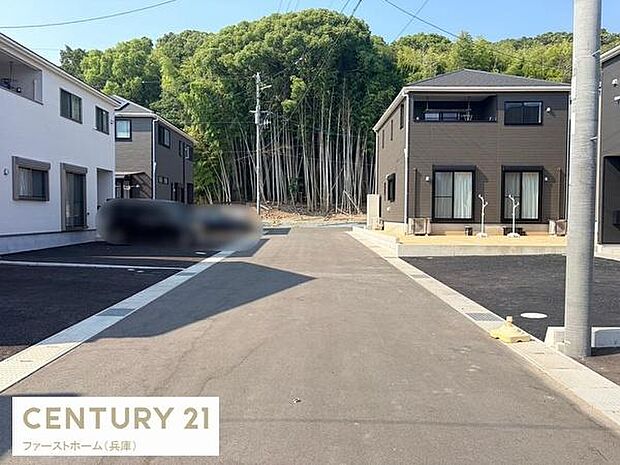 ゆとりのある前面道路が印象的な現地写真です。道路幅が広く車の出入りもスムーズに行えます。周囲には新しい住宅が建ち並び落ち着いた街並みが広がっています。自然豊かな景観を背景にした静かな住環境です。