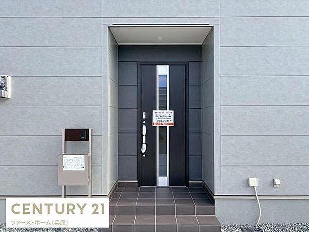 モダンなデザインが印象的な玄関です。タイル張りのアプローチが落ち着いた雰囲気を演出します。幅のある玄関ドアは出入りもスムーズです。宅配ボックスが設置されており実用性にも配慮されています。