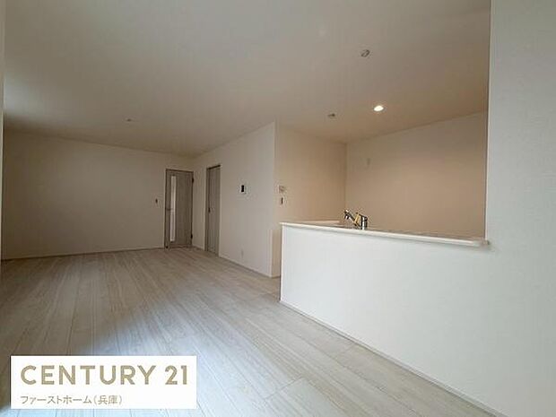 リビングは明るい色合いのフローリングが広がっています。壁や天井もシンプルですっきりとした雰囲気です。キッチンとの一体感が感じられ空間を有効活用できます。照明も天井に設置されており統一感があります。