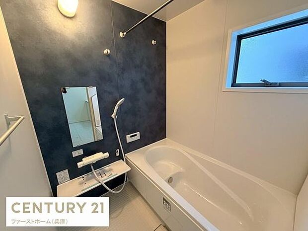 落ち着いた色調の壁面デザインが印象的なバスルームです。広めの浴槽でゆったりと過ごせます。大きめの窓があり明るい空間になっています。シャワーと鏡が使いやすい位置に配置されています。