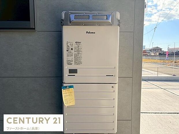 屋外設置の給湯器が設置されています。シンプルなデザインで外壁との調和が取れています。操作パネルも見やすく使い勝手に配慮されています。角地に位置しており開放感のある配置です。