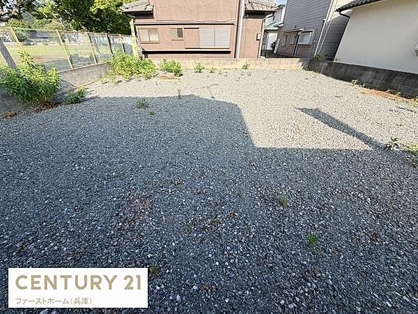 現地土地写真では敷地全体が見渡せるため形状や広さをしっかり確認できます。周囲に塀があり隣接地との区切りも明瞭です。前面道路や隣家の様子も写っており環境の把握に役立ちます。