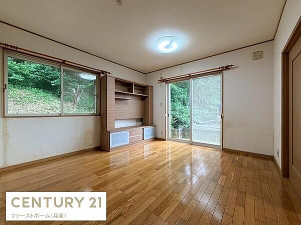 大きな窓とガラス扉から緑の景色が楽しめるリビングです。室内は木目フローリングで落ち着いた雰囲気です。収納棚付きで整理整頓もスムーズです。自然光がたっぷり入ります。