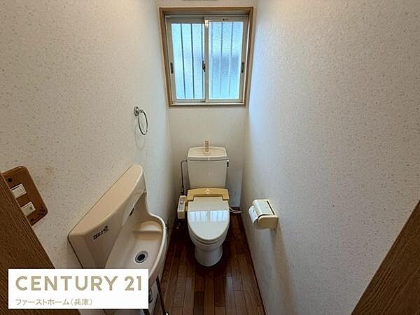 窓付きで換気しやすいトイレです。落ち着いた色合いのフローリングが特徴です。手洗い器も備えられており使い勝手の良い空間となっています。紙巻き器やタオル掛けも設置されています。