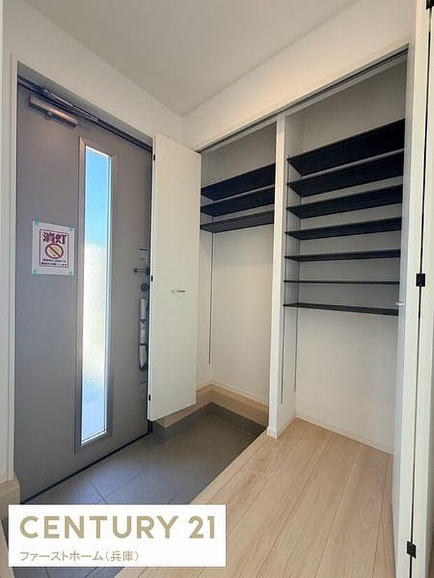 玄関には収納棚が備え付けられており整理整頓がしやすい空間です。明るい採光が入る玄関ドアが特徴的です。すっきりとした印象の内装が広がっています。シンプルなデザインで使い勝手の良さが感じられます。