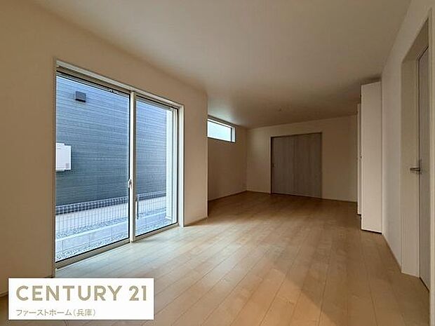 明るい光が差し込むリビングは開放感のある空間です。シンプルな内装でさまざまなインテリアに合わせやすい雰囲気です。大きな窓が外とのつながりを感じさせます。床の木目が温かみを演出しています。