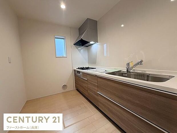 シンプルで清潔感のあるキッチンです。十分な収納スペースが確保されています。換気扇により快適な調理環境をサポートします。手元を明るく照らす照明が設置されています。