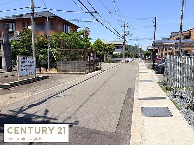 前面道路は幅員があり車の通行がしやすい環境です。周辺には住宅が並び静かな雰囲気が感じられます。電柱や配線も整然としており道路沿いには歩道が整備されています。日当たりも確保できる道路状況です。