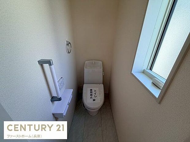 シンプルで使いやすいトイレ空間です。小窓付きで自然光がしっかり入ります。白を基調とした内装が清潔感を感じさせます。収納やペーパーホルダーも設置されています。