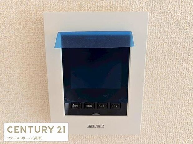 シンプルなデザインのモニター付きインターホンが設置されています。操作ボタンもわかりやすく配置されています。見やすいディスプレイで来客確認が可能です。壁にすっきり納まる設計です。