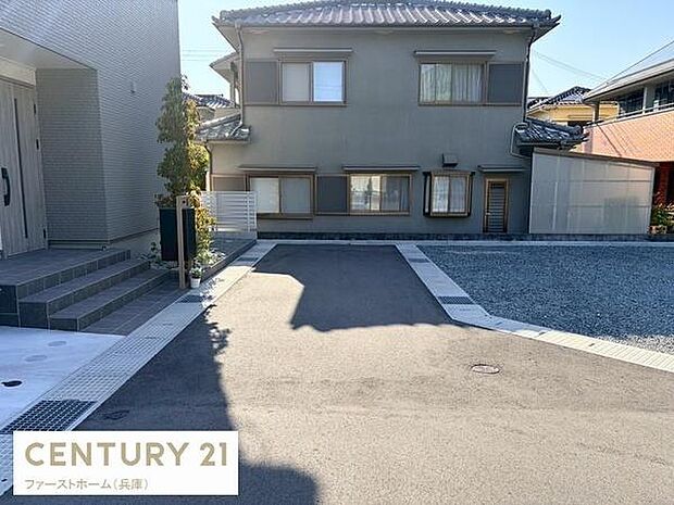 現地の前面道路は舗装されており落ち着いた雰囲気が感じられます。建物の外観や周囲の住宅も確認でき周辺の様子も一目でわかります。