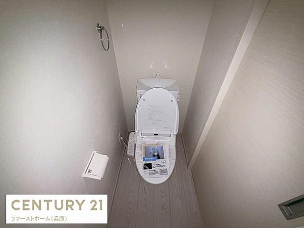 シンプルなデザインで清潔感のあるトイレです。空間がしっかり確保されゆったりと使用できます。ペーパーホルダーやタオルリングなど基本的な設備も整っています。壁や床も明るい色合いで統一されています。