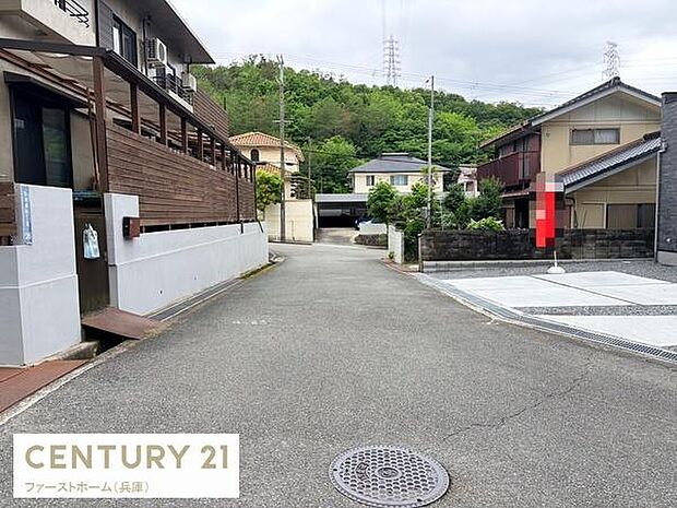 ゆるやかなカーブが美しい前面道路が印象的な現地写真です。周辺には住宅が立ち並び落ち着いた雰囲気が感じられます。道路幅も十分で車の出入りも安心です。視界の先には緑豊かなエリアが広がり自然も感じられます。