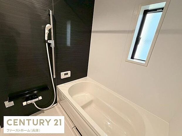 浴室には便利な窓があり自然光が取り入れやすい設計です。シンプルなカラーで清潔感があります。シャワーや棚もしっかりと配置されています。ゆったりとした浴槽が設けられています。換気面にも配慮されています。