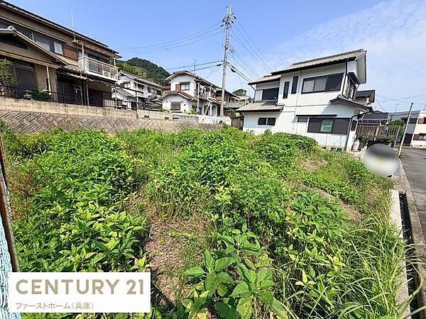 現地土地写真です。幅広い道路に面しており周囲には住宅が建ち並んでいます。周辺環境が整っており閑静な住宅街の一角に位置しています。現地の状況が一目でわかる写真となっています。