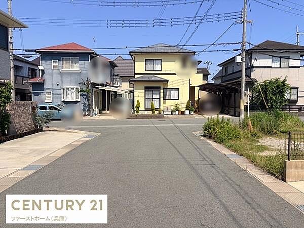 前面道路が広くゆとりある雰囲気が感じられる現地写真です。並びの住宅が整然としており周辺環境もすっきりとしています。道路沿いに草木も確認でき落ち着いた印象です。住宅街の様子がしっかりと分かる一枚です。