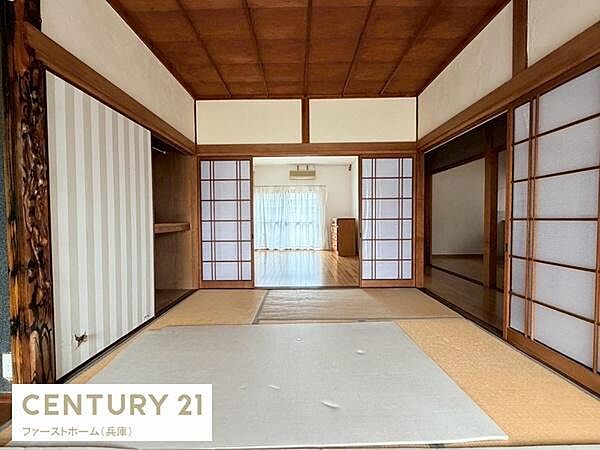 落ち着いた和の雰囲気が広がる和室です。障子から差し込む自然光が室内を明るく演出します。隣接する洋室と一体感のある空間構成も魅力です。収納スペースもすっきり設けられています。