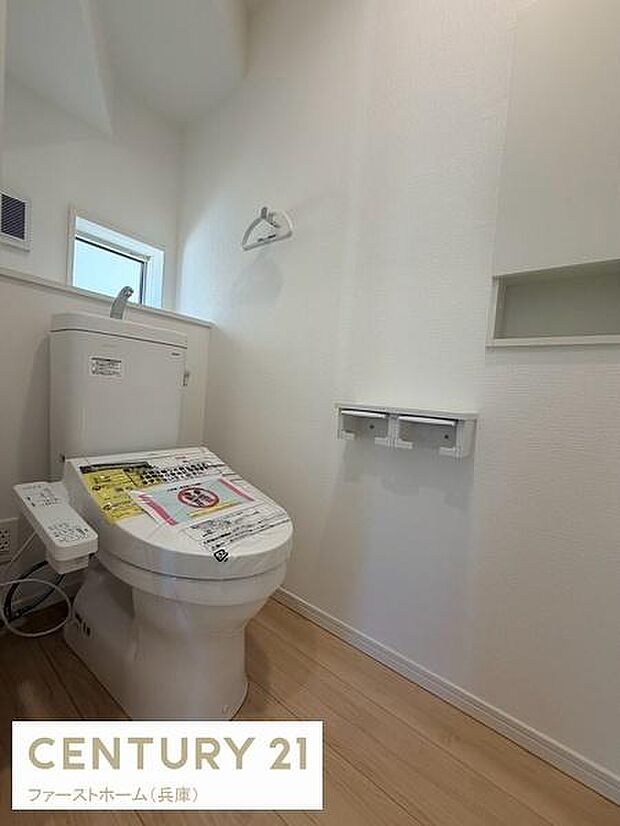 白を基調とした明るい内装が特長のトイレです。窓が設けられているため自然な明るさが感じられます。温水洗浄便座が備わっていて清潔感が保たれています。ペーパーホルダーは2連タイプで使い勝手が良いです。
