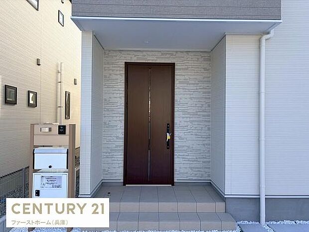 シンプルで落ち着いた雰囲気の玄関が印象的です。広めのポーチと上品な外壁デザインが魅力です。段差も低く使い勝手に配慮された作りです。宅配ボックス付きで便利さも備えています。