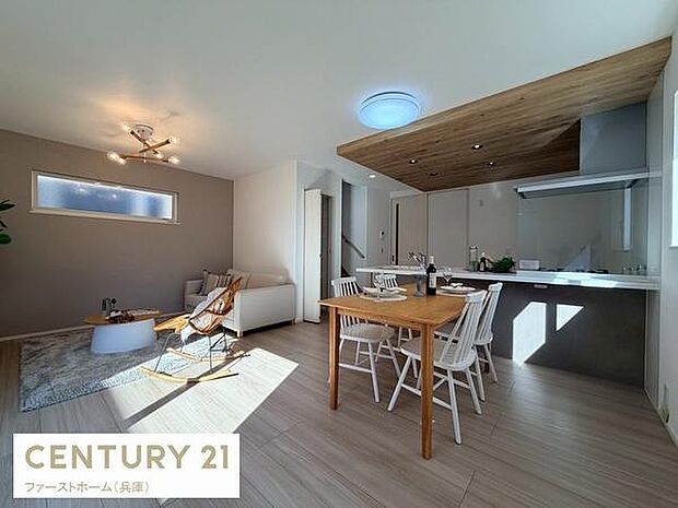 明るい光が差し込むリビングは広々とした空間が広がっています。木目調の天井が温かみを感じさせナチュラルな雰囲気です。キッチンとリビングが一体となった設計で使い勝手も良好です。