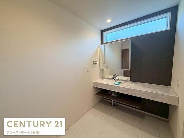 大きな窓からの明るい光が魅力の洗面台です。シンプルなデザインと広々とした空間が特徴となっています。収納スペースも確保されていますので使い勝手にも配慮されています。