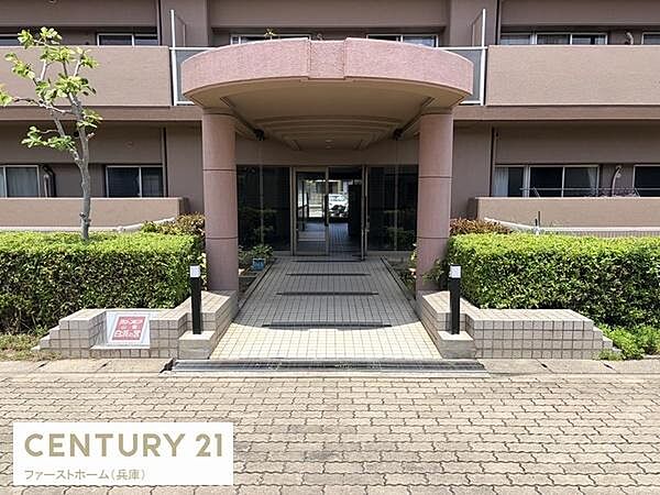 エントランスは落ち着いた色合いで建物全体の印象を引き立てています。アプローチ部分が広めに確保されています。植栽に囲まれた外観が特徴的です。屋根付きで雨天時の出入りも安心です。