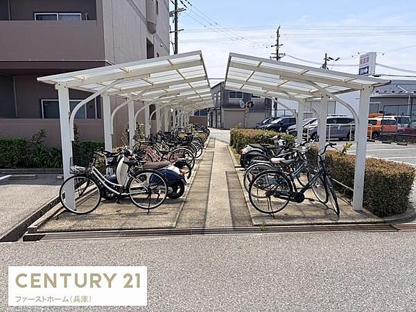 屋根付きの駐輪場が敷地内に完備されています。自転車やバイクが並べやすいスペースです。敷地がしっかり整備されています。周囲には植込みが配置されています。駐輪場は通路も広く使いやすいです。