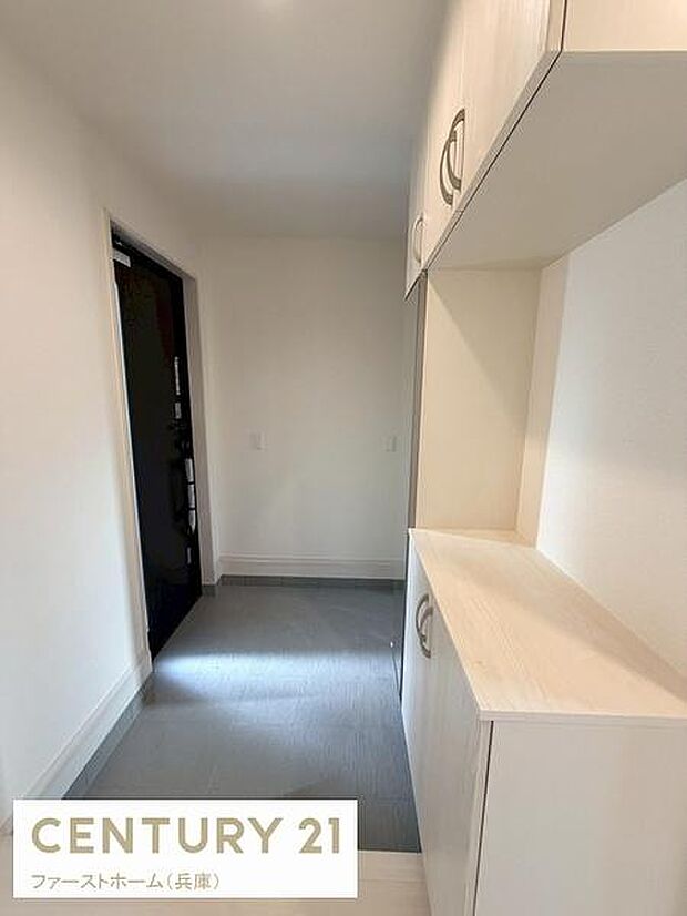 玄関は明るい雰囲気で収納スペースもしっかり確保されています。シンプルなデザインが清潔感を与えます。ゆとりのある空間設計で使いやすさが感じられます。床から天井までの収納で整理がしやすい構造です。