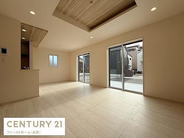 リビングは大きな窓からたっぷりと陽光が差し込み明るい空間が広がります。天井部分には木目調のアクセントが施され温かみを感じられます。床はナチュラルな色合いで落ち着いた雰囲気です。