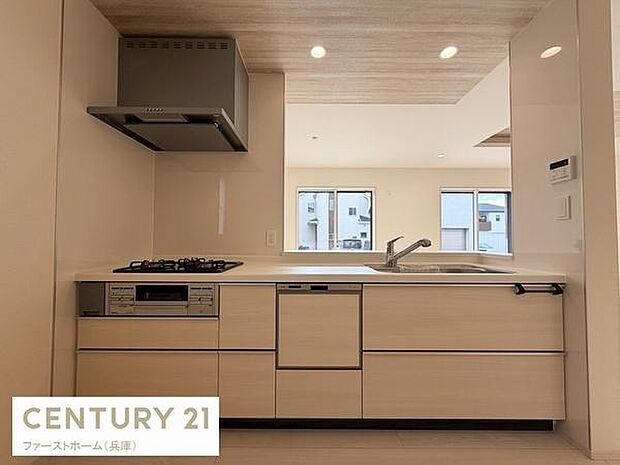 ナチュラルな色合いのキッチンが空間に調和しています。窓からの明るい採光が手元を照らします。効率的な配置で使いやすさにも配慮されています。収納スペースも豊富に確保されています。