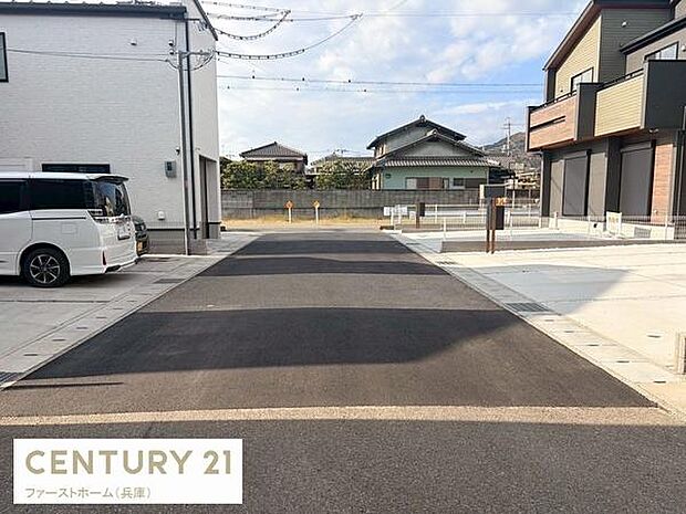 前面道路はゆとりのある幅員で車の出入りがしやすい設計です。舗装された道路が敷地までしっかりと続いており視界も開けています。周辺は住宅が整然と並び落ち着いた雰囲気が広がっています。