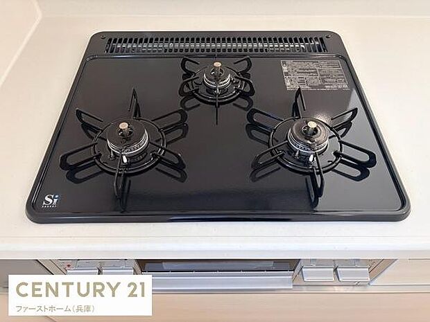 三口コンロで調理がスムーズに行えます。フラットな天板はお手入れも簡単です。シンプルなデザインがキッチンの印象を引き締めています。ガスコンロ周辺も広く使える配置が特徴的です。