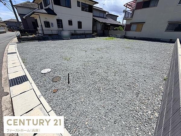 道路に面した整形地で住居や店舗など多目的に活用しやすい現地土地写真です。周囲には住宅が立ち並び落ち着いた雰囲気が感じられます。日当たりも良好で敷地の形状も扱いやすい点がポイントです。