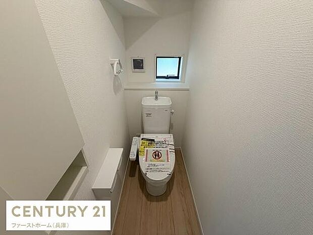 コンパクトながらも清潔感のあるトイレ空間です。小窓付きで通気性も確保されています。壁面収納が備え付けられているため整理もしやすい設計です。温水洗浄便座が設置されている点もポイントです。