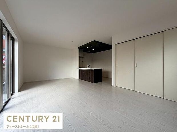 リビングは大きな窓から光がたっぷりと入り明るさが印象的です。ナチュラルカラーの床が開放感を引き立てます。キッチンカウンターとの一体感も魅力です。収納スペースも充実しておりすっきりとした印象です。