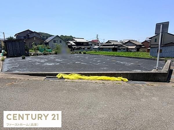 現地土地写真から広々とした区画が確認できます。周囲には住宅が立ち並び落ち着いた環境が感じられます。道路と隣接しており車両の出入りも便利です。現地の状況をしっかりとご覧いただけます。