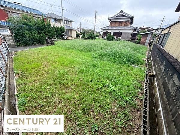 現地土地写真です。敷地が広く周囲に住宅が建ち並ぶ落ち着いた雰囲気です。両側にフェンスが設置されているため敷地境界も明瞭です。自然光もしっかり差し込んでいます。周辺道路や隣接地とも調和した立地です。