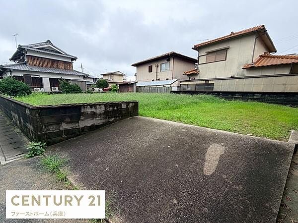 落ち着いた住宅街に位置する現地土地写真です。周囲には建物があり安心感があります。広さがあり使い勝手の良い土地です。平坦な地形で多様な活用が可能です。道路からの出入りもしやすい区画です。
