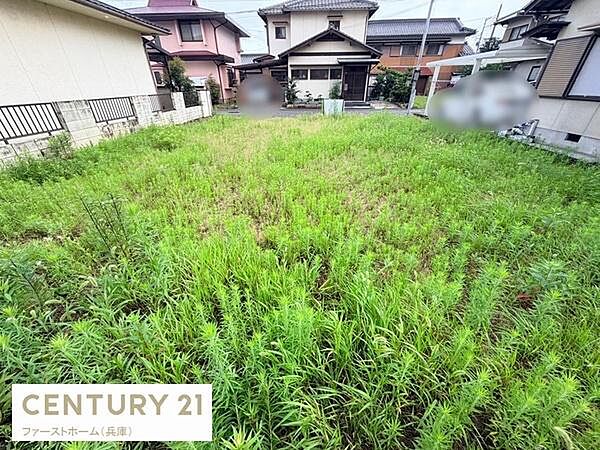 広々とした現地土地写真です。住宅が立ち並ぶ穏やかなエリアに位置しています。周囲はきちんと整備されており明るい雰囲気が魅力です。両側にフェンスが設置されており安心感もあります。