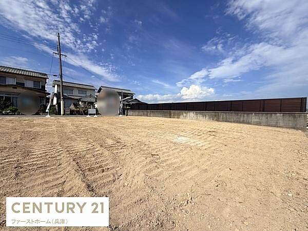 すっきりと整地された土地写真です。周囲は住宅が並び前面には広い空間が広がっています。空の広がりが感じられる現地写真です。道路からのアクセスが分かりやすくなっています。現地の様子が一目でわかります。