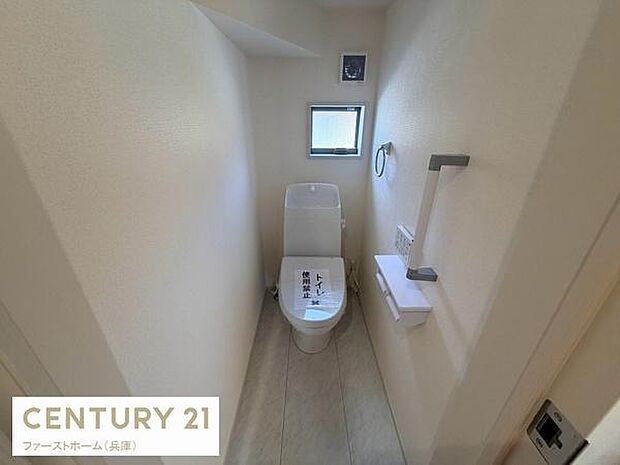 窓付きで明るい印象のトイレです。手すりが設置されており安心してお使いいただけます。白を基調とした清潔感のある空間です。ペーパーホルダーや棚も備わっています。